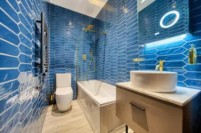 a blue tiled bathroom with a sink and a toilet at Stunning Central Station 1 Bed Apartment A7 in Glasgow