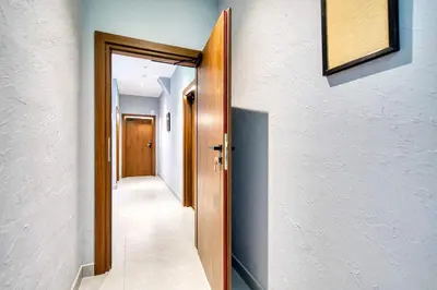 a hallway with a door leading to a room with white walls at Stunning Central Station 1 Bed Apartment A7 in Glasgow