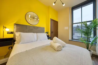 a bedroom with a large bed with a clock on the wall at Cozy Central Station 1 Bed Apartment B8 in Glasgow