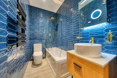 a blue tiled bathroom with a sink and a toilet at Cozy Central Station 1 Bed Apartment B8 in Glasgow
