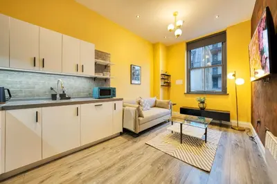 a kitchen and a living room with yellow walls at Lovely Central Station 1 Bed Apartment B10 in Glasgow