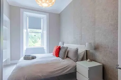 a bedroom with a bed with pillows and a window at Spacious 3 bed home in Marchmont in Edinburgh