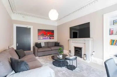 a living room with a couch and a fireplace at Spacious 3 bed home in Marchmont in Edinburgh