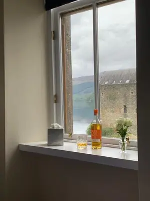 a bottle of whisky sitting on a window sill at Tower View Apartment in Carrick