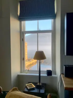 a lamp sitting on a table in front of a window at Tower View Apartment in Carrick