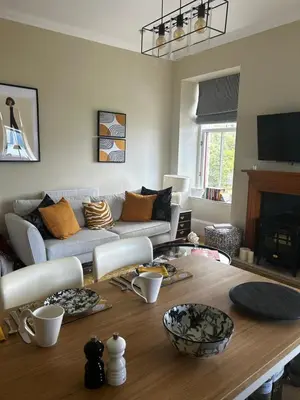a living room with a table and a couch at Tower View Apartment in Carrick