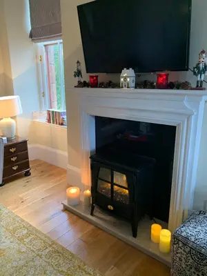a living room with a fireplace with a television above it at Tower View Apartment in Carrick