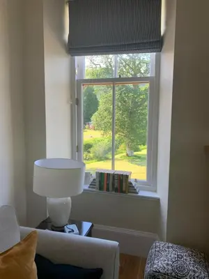 a living room with a window with a couch and a lamp at Tower View Apartment in Carrick