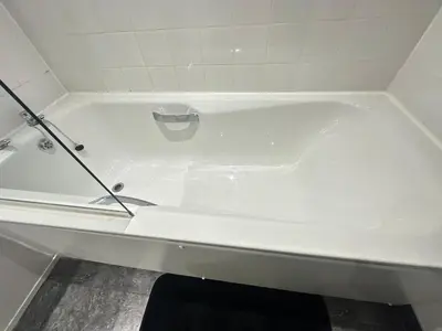 a white bath tub in a white tiled bathroom at Glasgow City Centre Stylish Flat in Glasgow