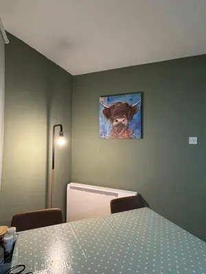 a room with a table and a painting of a dog at Cozy Central Flat near Edinburgh Castle and with Free Private Parking in Edinburgh