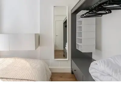 a bedroom with a large mirror and a bed at The Gardners apartment in City centre with parking in Edinburgh