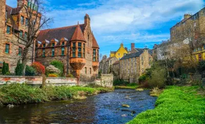 a river in the middle of a city with buildings at The Gardners apartment in City centre with parking in Edinburgh