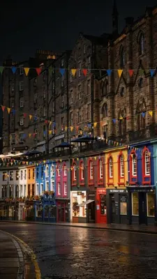 a group of buildings with colorful lights on them at The Gardners apartment in City centre with parking in Edinburgh