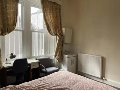 a bedroom with a bed and a desk and a window at Gilmore Flat in Edinburgh
