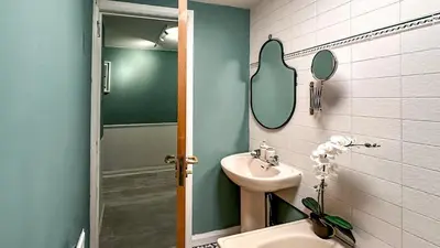 a bathroom with a sink and a toilet and a mirror at Sunny day new flat with 5 beds in Clydebank