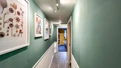 a hallway with green walls and a hallway with a hallway at Sunny day new flat with 5 beds in Clydebank