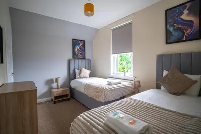 a bedroom with two beds and a window at Caledonia Apartment in South Cobbinshaw
