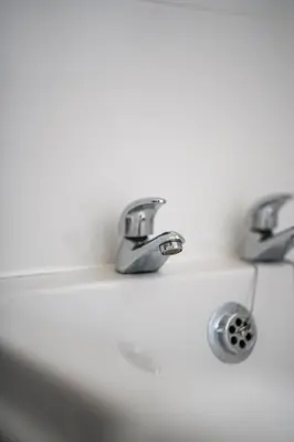 a bathroom sink with two faucets on it at Castlefern House in Rutherglen