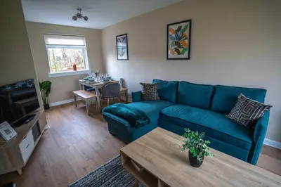 a living room with a blue couch and a table at Castlefern House in Rutherglen