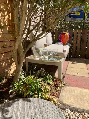 a table with glasses on it next to a tree at The Bunker, Golf Cottage in Prestwick