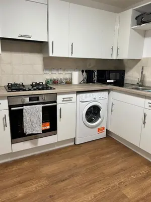 a kitchen with white cabinets and a washing machine at Charming home away from home! in Edinburgh