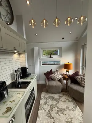 a kitchen with a counter and a couch in a room at Tumpseys Hideaway with Hot Tub & Sunset Loch Views, Glencoe Near Fort William in Ballachulish