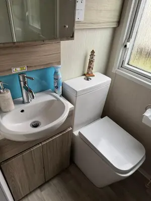 a small bathroom with a toilet and a sink at The Retreat - Turnberry Holiday Park Amazing Sea View in Girvan
