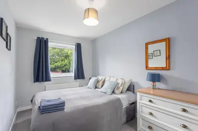 a bedroom with a bed and a window and a dresser at Modern flat near Murrayfield stadium, sleeps 4 in Edinburgh