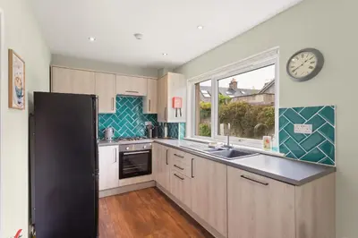 a kitchen with a black refrigerator and a clock on the wall at Modern flat near Murrayfield stadium, sleeps 4 in Edinburgh