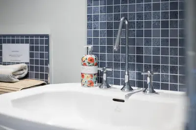 a sink with two faucets in a bathroom at Modern flat near Murrayfield stadium, sleeps 4 in Edinburgh