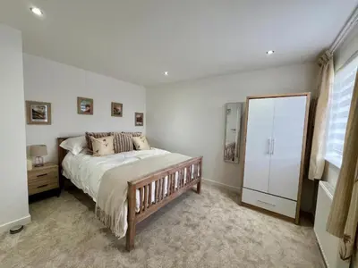 a bedroom with a large bed and a mirror at Dunmuir House 4 Bedroom 2 bathroom House & Garden in Denny in Falkirk