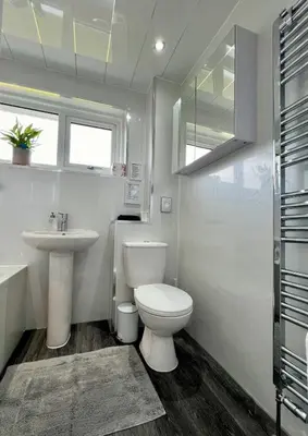 a white bathroom with a toilet and a sink at Dunmuir House 4 Bedroom 2 bathroom House & Garden in Denny in Falkirk