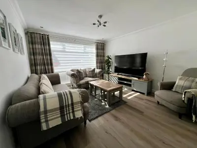 a living room with a couch and a tv at Dunmuir House 4 Bedroom 2 bathroom House & Garden in Denny in Falkirk
