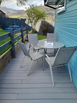 a table and chairs sitting on a deck at Wee Blue Hoose in Dalmally