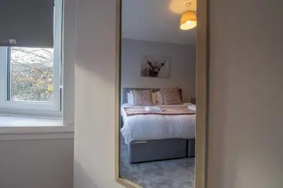 a mirror reflection of a bed in a bedroom at Kerr Apartment-Spacious 4-Bed Flat in Hamilton, Close to Glasgow in Cadzow