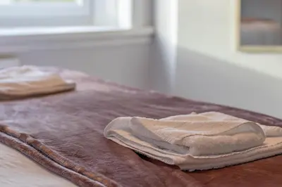 two folded towels sitting on top of a table at Kerr Apartment-Spacious 4-Bed Flat in Hamilton, Close to Glasgow in Cadzow