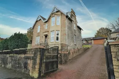 an old stone house with a fence in front of it at 10 Bedrooms Pool Table Garden Piano in Glasgow