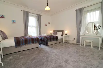 a bedroom with two beds and a mirror at 10 Bedrooms Pool Table Garden Piano in Glasgow