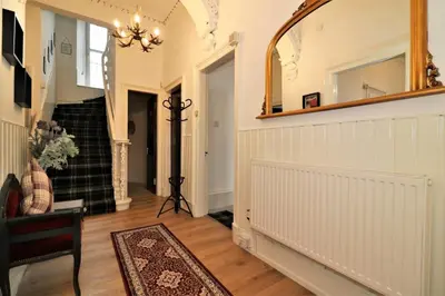 a hallway of a home with a mirror on the wall at 10 Bedrooms Pool Table Garden Piano in Glasgow