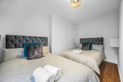 a bedroom with two beds with towels on them at 3 Bedrooms Homely House in Motherwell Sleeps 8 comfortably with 6 double beds Near Glasgow Edinburgh Free Private Parking Business Travellers Contractors Holiday Goers Near all Major transport links in Carfin