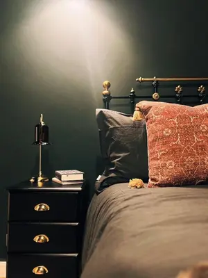 a bedroom with a bed and a night stand with a lamp at Central Designer Flat by Castle in Edinburgh