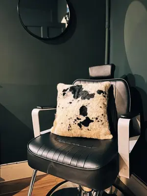 a black leather chair with a pillow on it at Central Designer Flat by Castle in Edinburgh