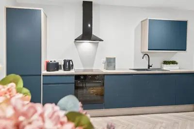 a kitchen with blue cabinets and a sink at The Post Office in Torphichen