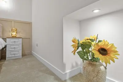 a vase filled with yellow flowers in a bedroom at The Post Office in Torphichen