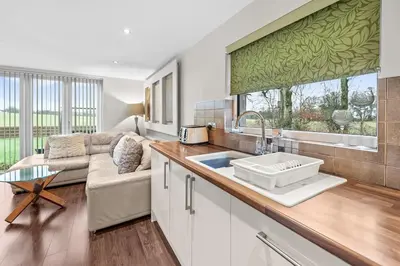 a kitchen with a sink and a living room at Westcraigs in Westfield