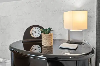 a table with a clock and a lamp on it at Westcraigs in Westfield