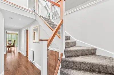 a staircase in a home with white walls and wood floors at Westcraigs in Westfield