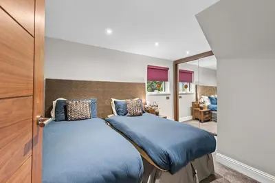 a bedroom with two beds with blue sheets at Westcraigs in Westfield