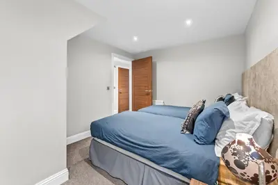 a bedroom with a bed with blue sheets and pillows at Westcraigs in Westfield