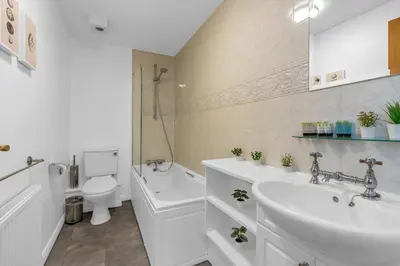 a bathroom with a sink and a toilet and a tub at Modern 2 bedroom apartment in City Centre in Edinburgh